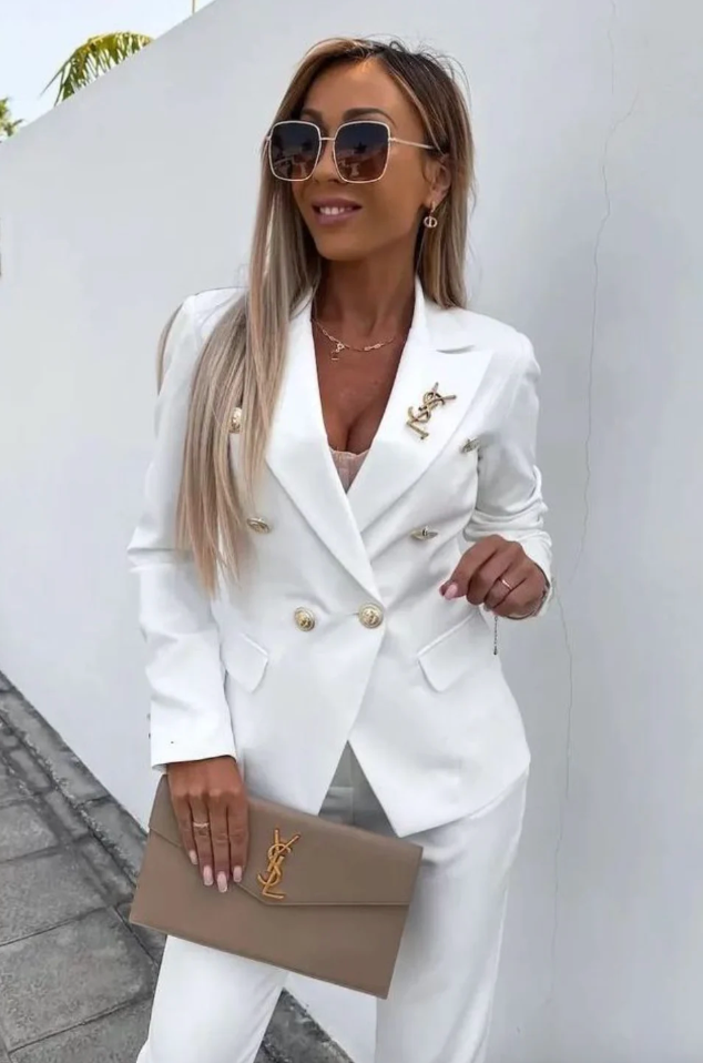 Women's tailored suit. Double-breasted blazer & slim trousers styled with a blouse for office elegance.