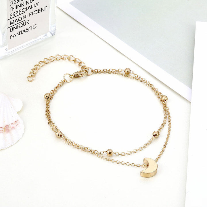Chic women's double-layered moon charm anklet, adjustable silver/gold accessory.