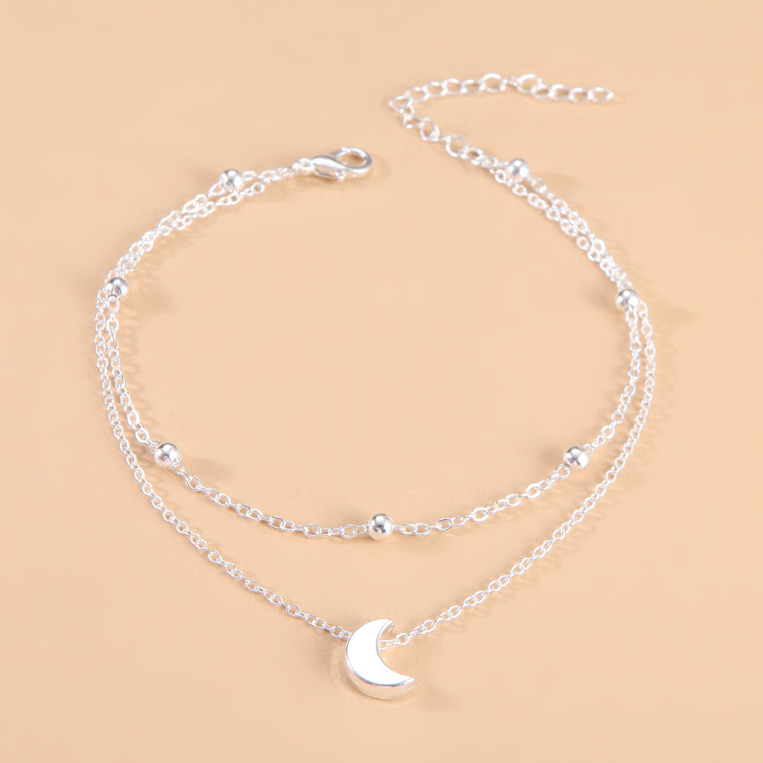 Stylish women's celestial moon charm anklet, elegant double-layered silver/gold jewelry.