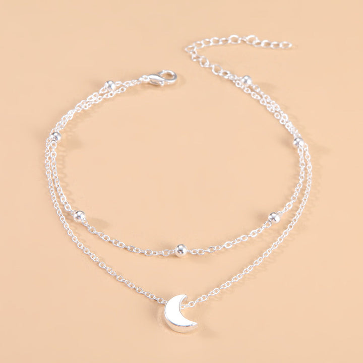 Stylish women's celestial moon charm anklet, elegant double-layered silver/gold jewelry.
