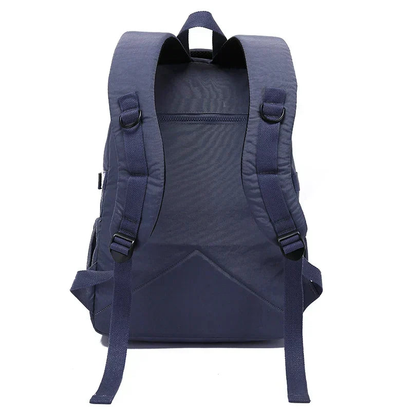 Women's durable water-resistant nylon backpack, shown resisting light rain during commute.
