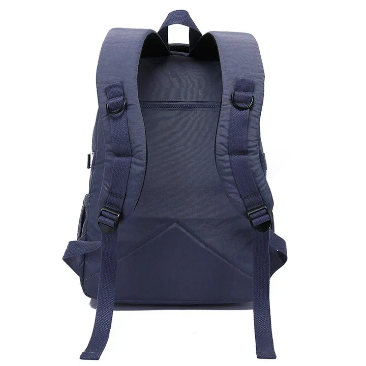 Women's durable water-resistant nylon backpack, shown resisting light rain during commute.