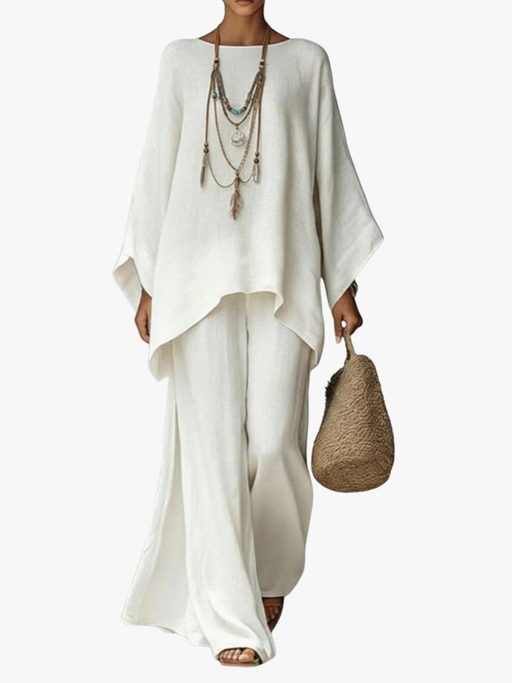 Women's effortless linen two-piece maxi set with poncho top & straight leg trousers, ideal for summer resort wear.