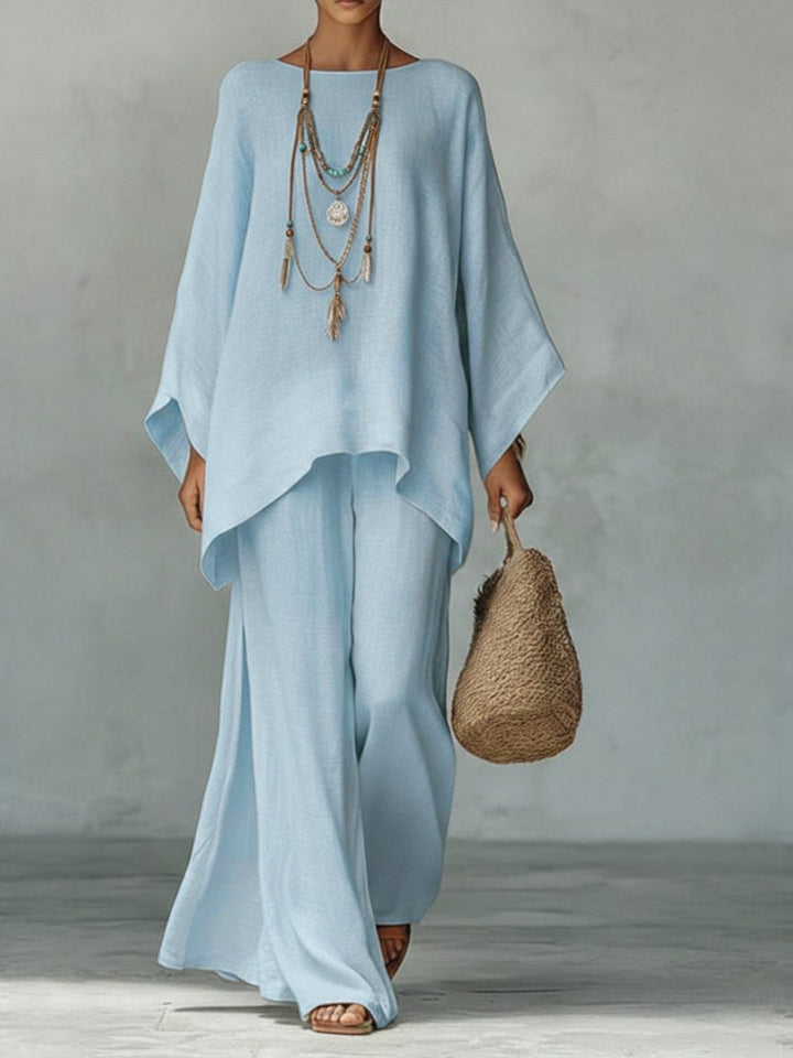 Stylish women's linen two-piece set: loose poncho top & comfortable straight leg maxi trousers, perfect for summer outfits.
