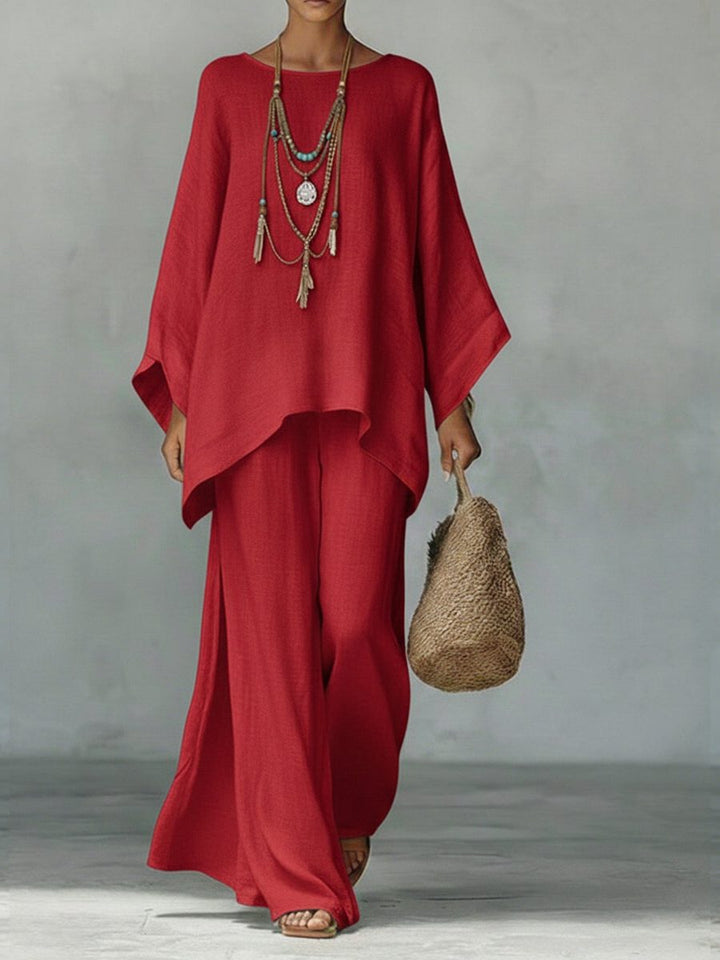Close-up of women's linen two-piece maxi set, showcasing texture of poncho top and straight leg trousers, resort wear.