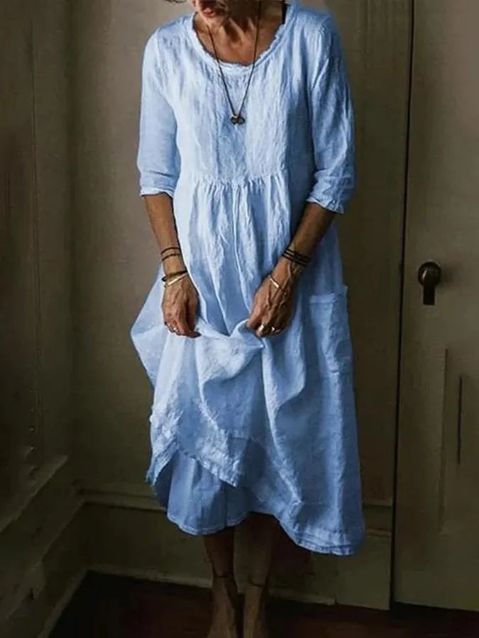 Women's effortless loose fit midi dress in a vibrant color, featuring practical pockets and comfortable 3/4 sleeves.