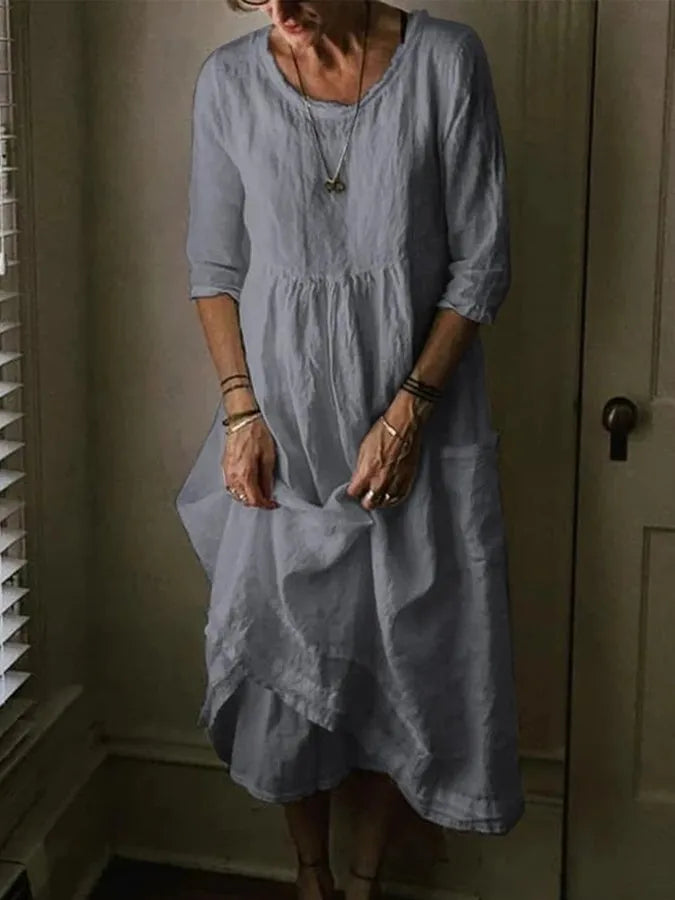 Stylish women's loose fit midi dress, showing a relaxed silhouette, 3/4 sleeves, and functional front pockets.