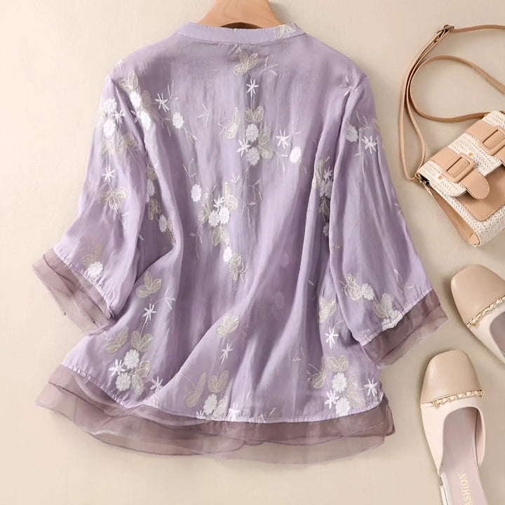 Elegant women's short-sleeve top with delicate floral embroidery, flattering & versatile.