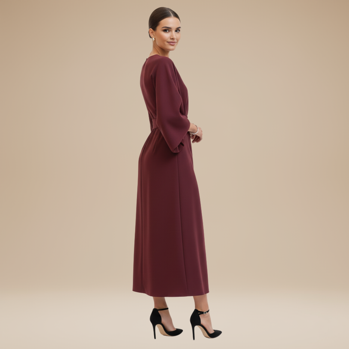 Posed model in a women's fashion-forward belted wide sleeve wrap midi dress, showcasing its elegant design.