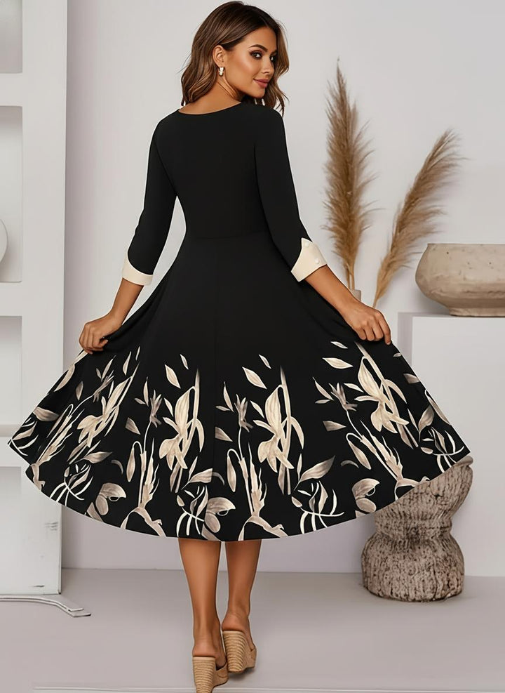 Sophisticated women's black floral A-line midi dress with elegant three-quarter sleeves, suitable for evening wear.