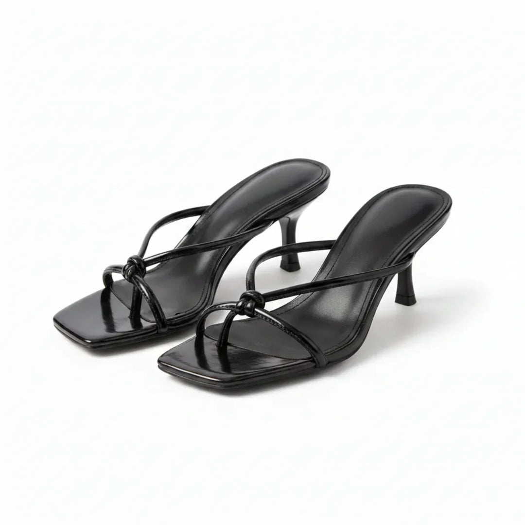 Fashionable women's knot heeled sandals worn on foot, providing stylish summer comfort for any occasion.