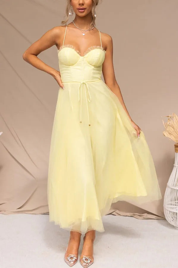 Women's elegant corset bodice midi dress with strappy details and layered skirt, perfect for wedding guests.