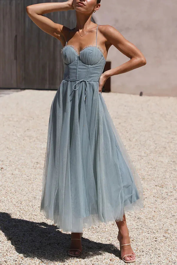 Women's formal midi dress showcasing a structured corset bodice, delicate straps, & a graceful layered skirt.