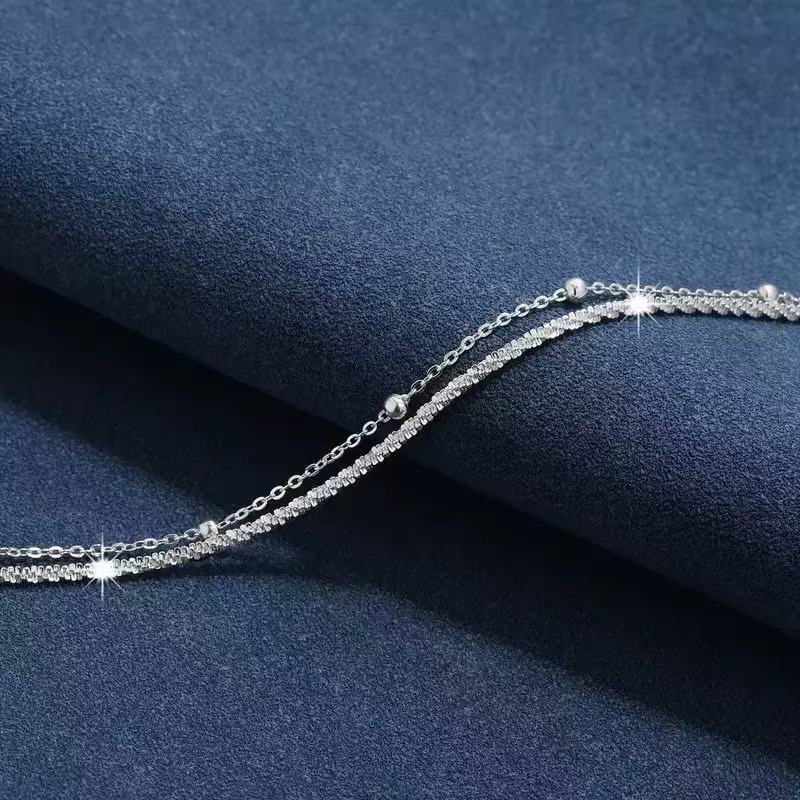 Stylish women's silver dual-layered bracelet worn on a wrist, perfect for elegant or minimalist fashion.