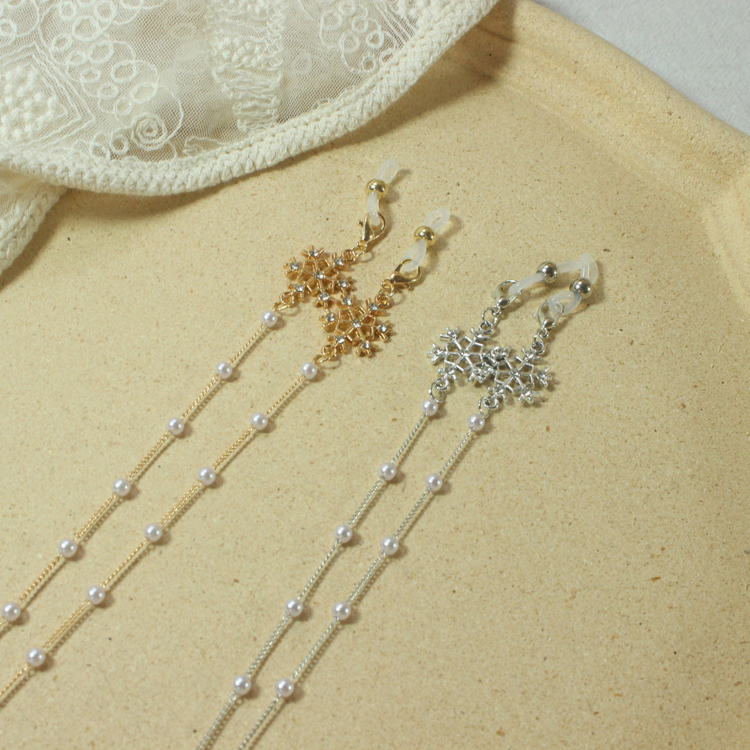 Fashionable pearl spectacle chain for women, adorned with a sparkling snowflake pendant, secure eyewear holder.
