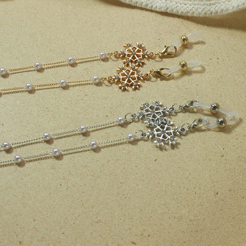 Stylish women's eyewear holder chain with elegant pearls & a festive snowflake design.