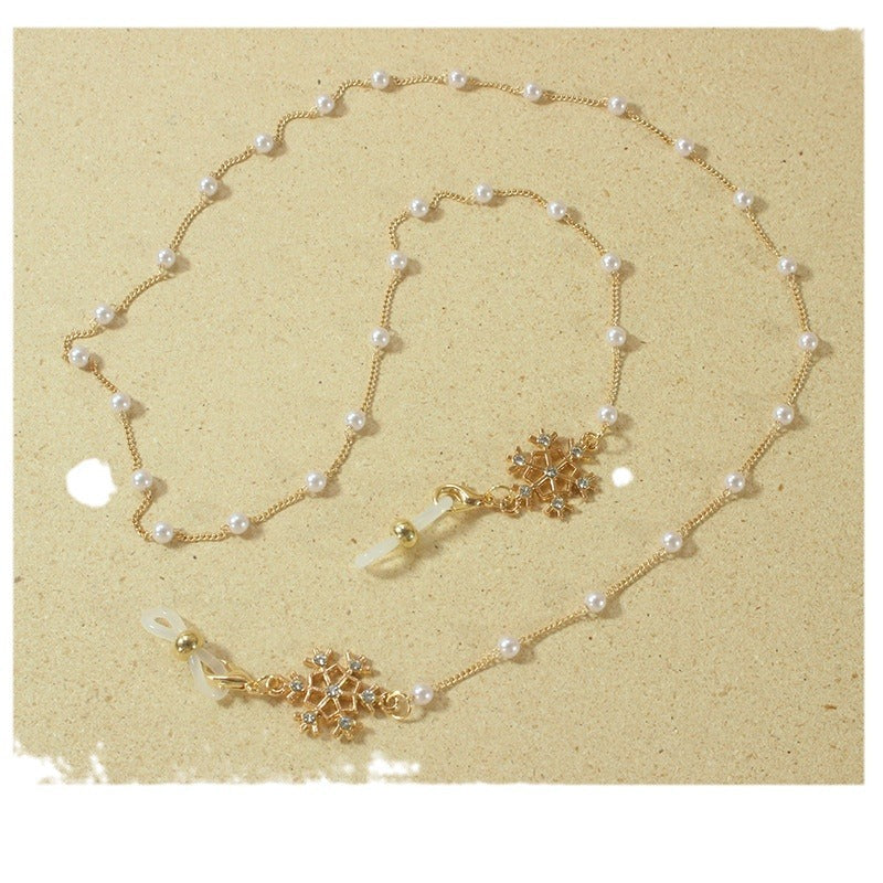 Elegant pearl eyeglass chain for women with a delicate snowflake pendant, practical & chic accessory.