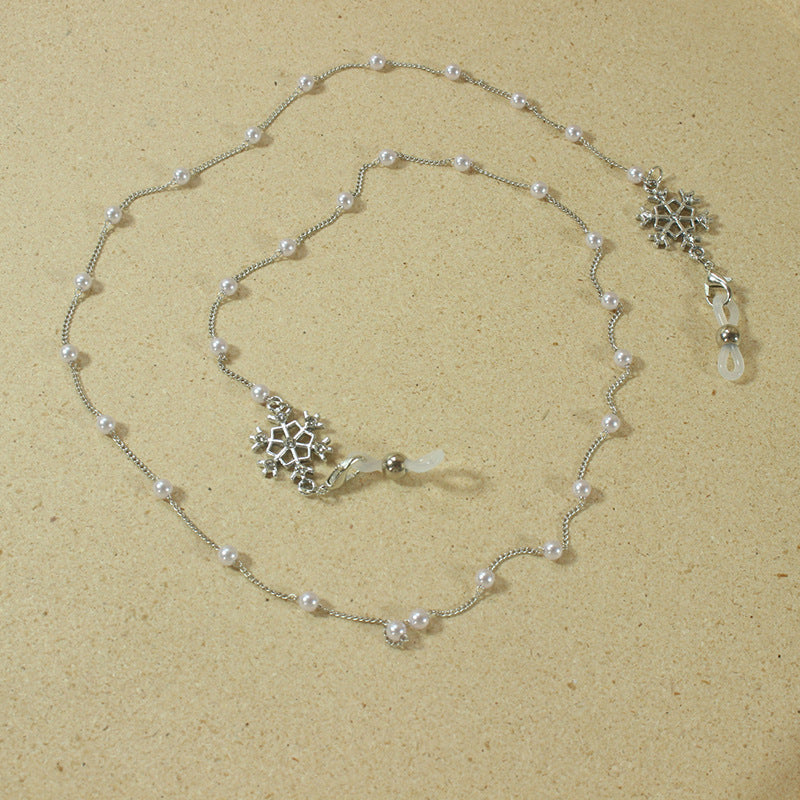 Women's chic pearl eyeglass chain with a snowflake pendant. Elegant eyewear holder & jewelry accessory.