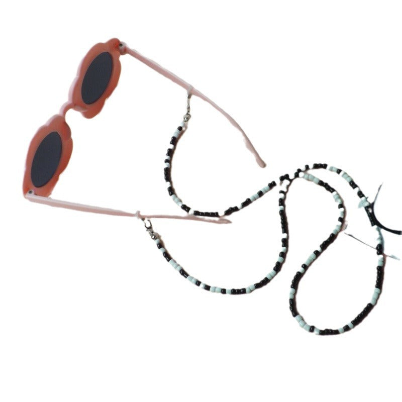 Luxurious women's flower sunglasses with an elegant beaded strap, ideal fashion accessory for sun protection.