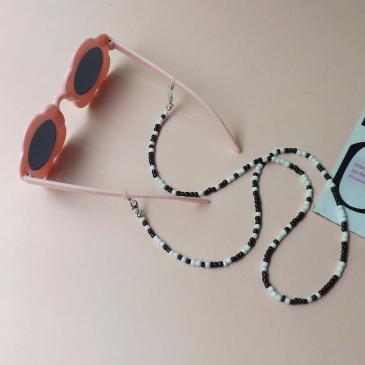 Women's stylish flower sunglasses, lightweight with a decorative beaded strap for UV protection & summer fashion.