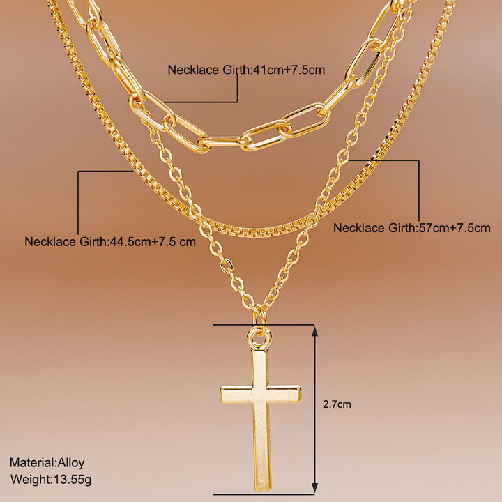 Stylish women's multi-layered gold necklace featuring a delicate cross pendant. Modern spiritual fashion jewelry.