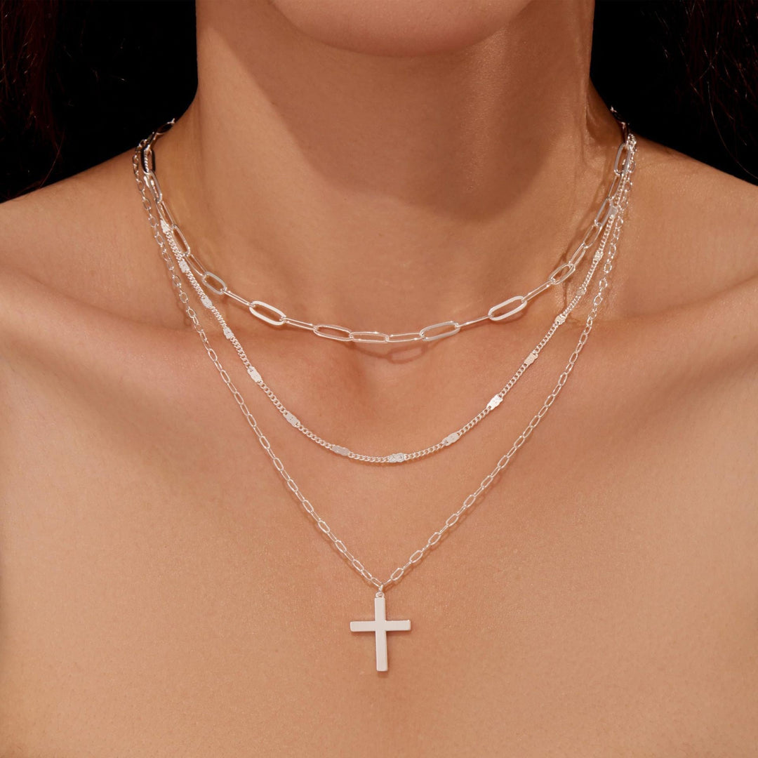 Delicate gold multi-layered necklace for women, adorned with a graceful cross pendant. Elegant spiritual accessory.