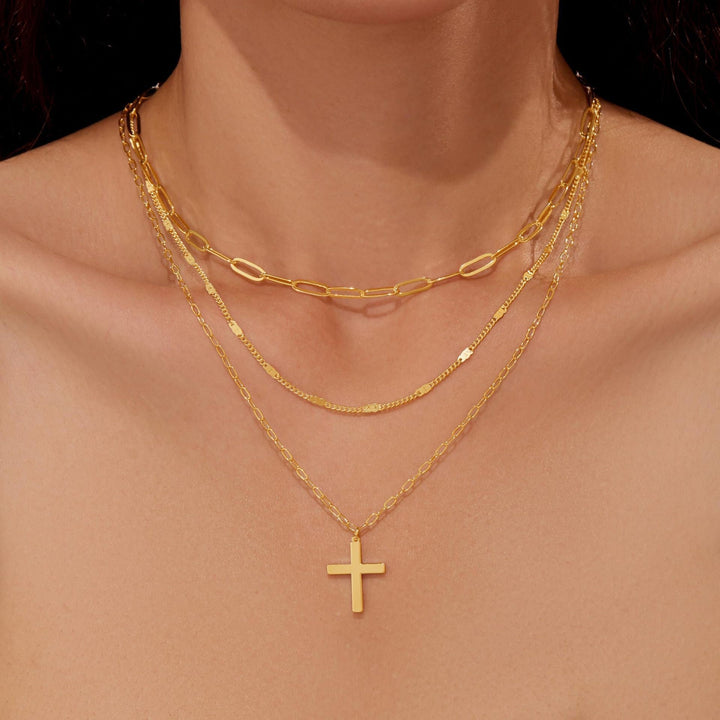 Fashionable women's gold layered necklace, featuring a symbolic cross pendant. Elegant and spiritual jewelry gift.