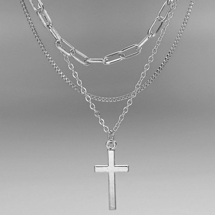 Chic multi-layered gold necklace for women, showcasing a spiritual cross pendant. Modern elegant fashion jewelry.