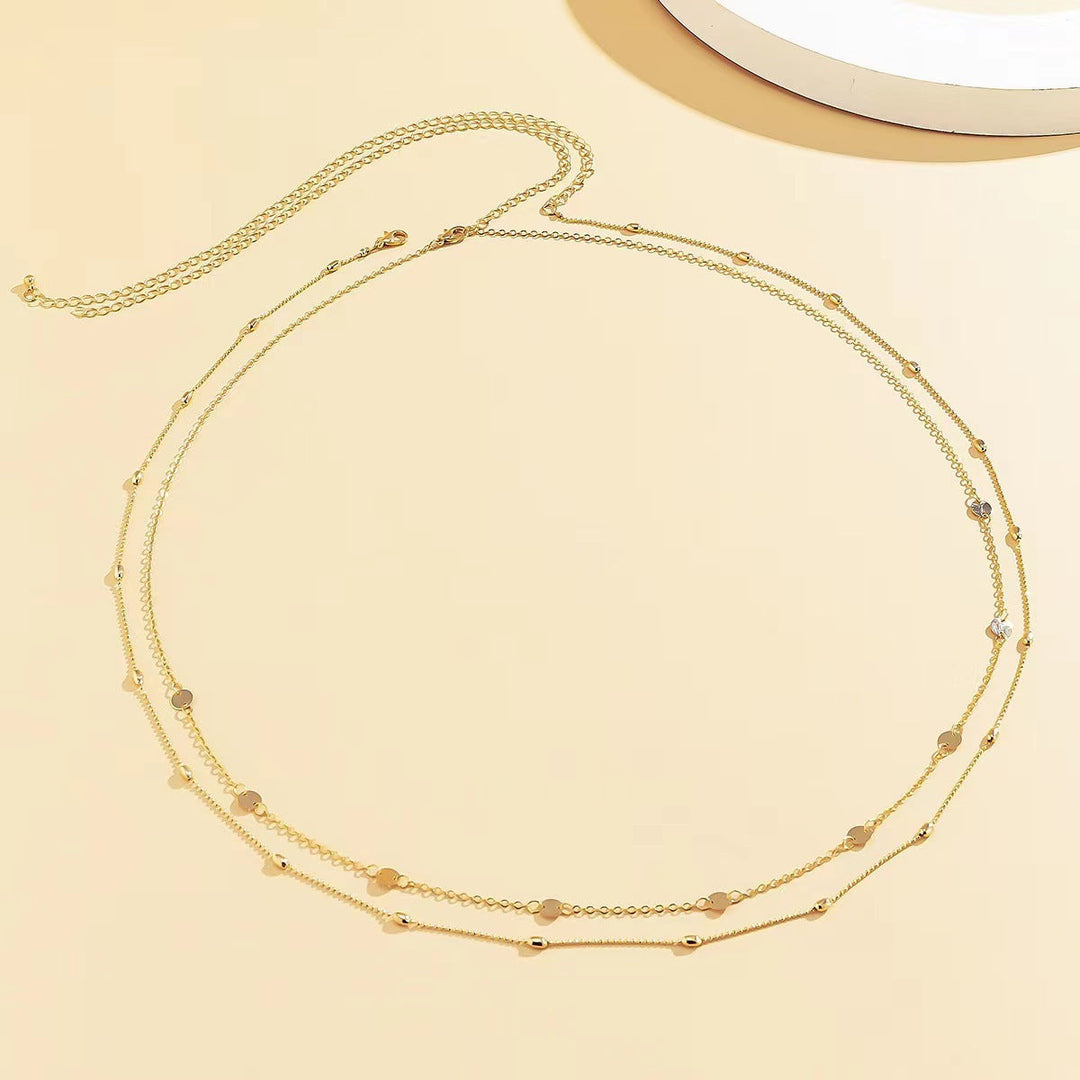 Delicate women's layered necklace featuring multiple gold-tone chains and charming pendants.