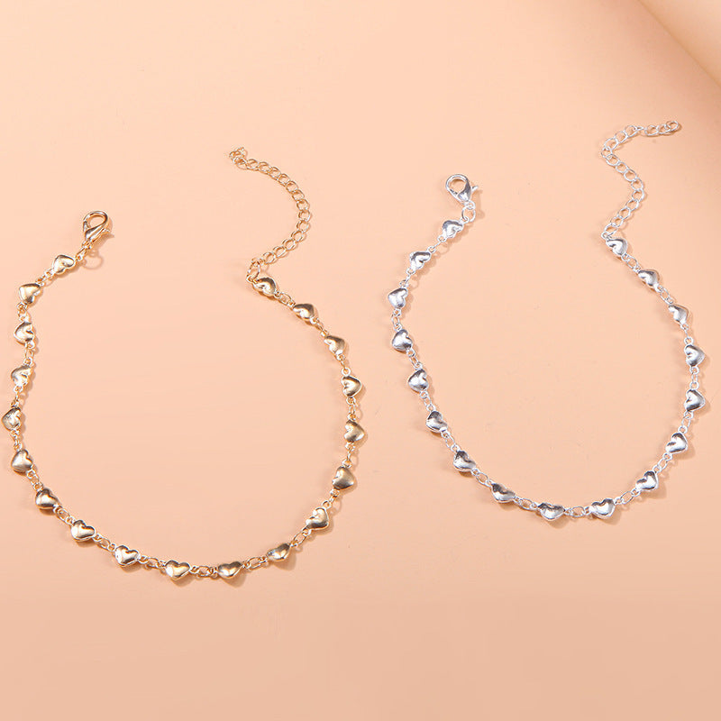 Dainty gold chain anklet for women with a delicate heart charm, adjustable summer accessory.