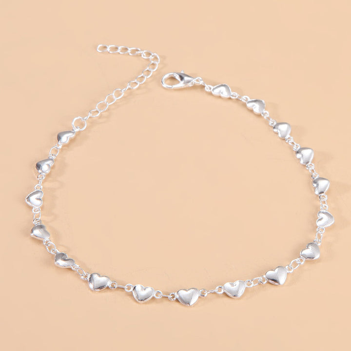 Delicate heart charm chain anklet, a stylish women's summer accessory & adjustable foot bracelet.