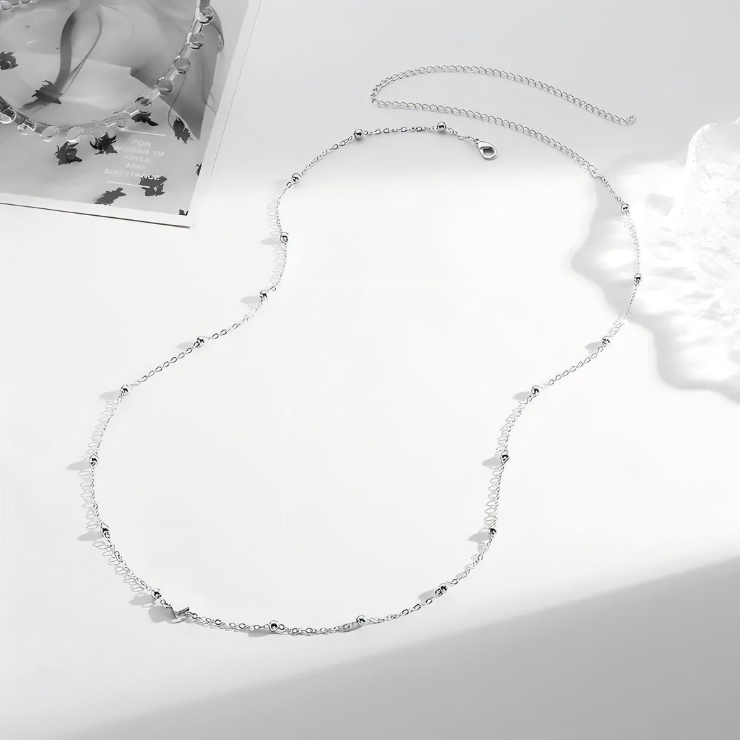 Chic women's layered necklace, delicate gold-tone chains with varied charms. Elegant and adjustable fashion accessory.