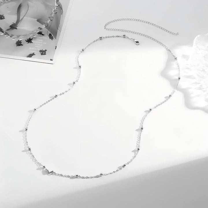 Chic women's layered necklace, delicate gold-tone chains with varied charms. Elegant and adjustable fashion accessory.