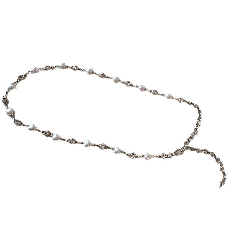 Close-up of a luxurious pearl necklace for women, adorned with intricate heart pendants and a smooth finish.