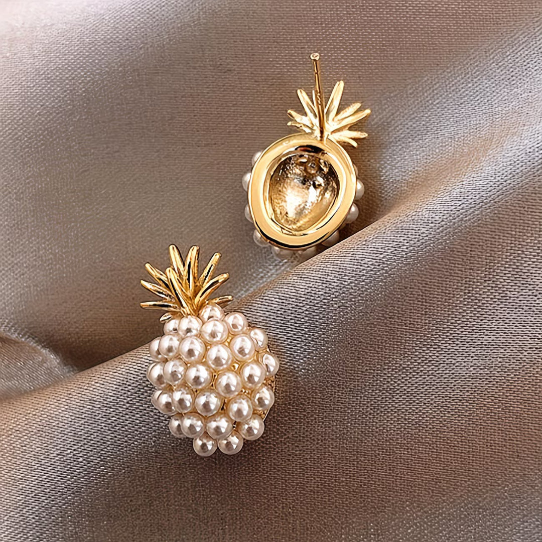 Stylish women's dangle earrings with lustrous pearls and golden pineapple charms.
