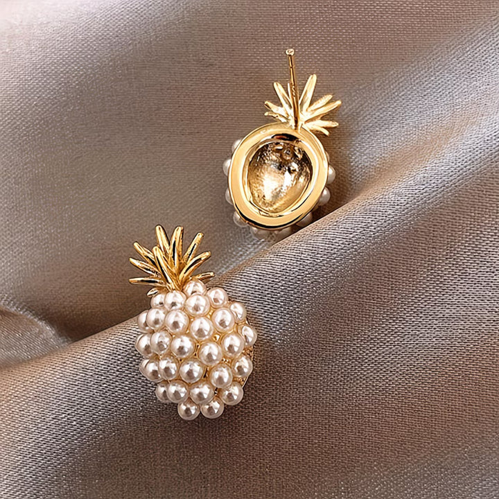 Stylish women's dangle earrings with lustrous pearls and golden pineapple charms.