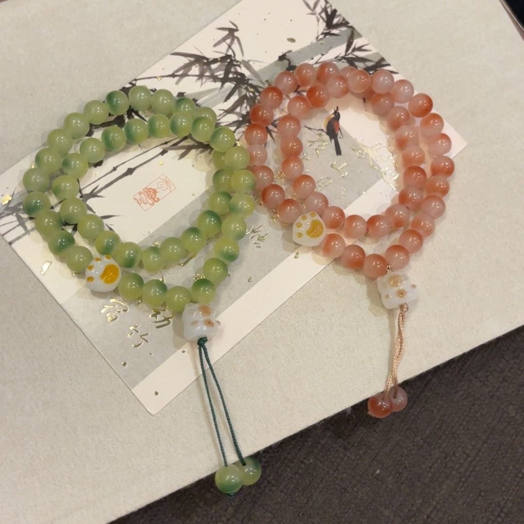 Close-up of women's semi-precious stone friendship bracelet, pink and green elegant beads.