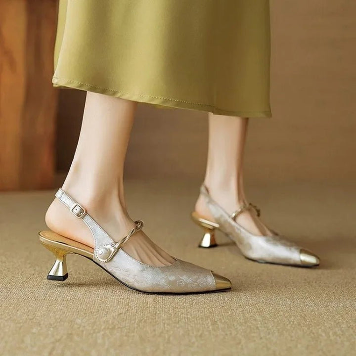 Elegant women's slingback sandals featuring a delicate pearl strap, pointed toe, and chic kitten heel. Smart dress shoes.
