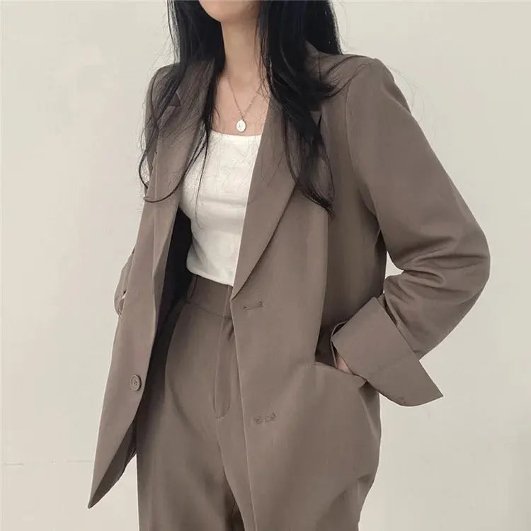 Tailored blazer & trouser set for women, embodying sophisticated business fashion.