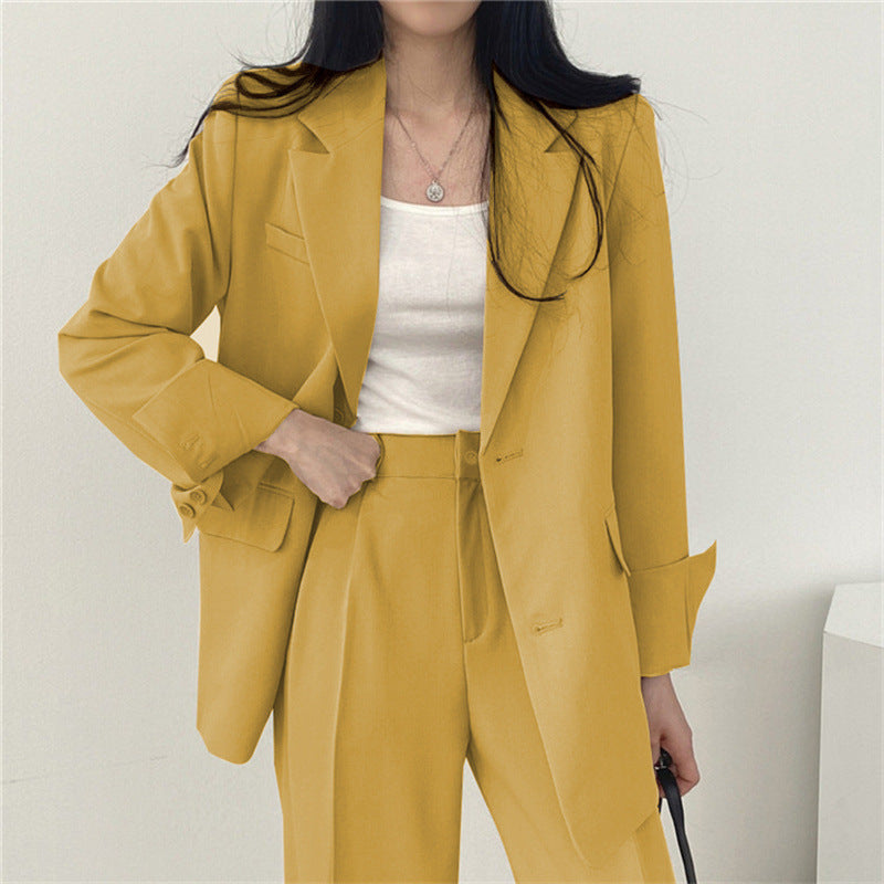 Women's elegant professional outfit, featuring a sleek tailored blazer and matching trousers.