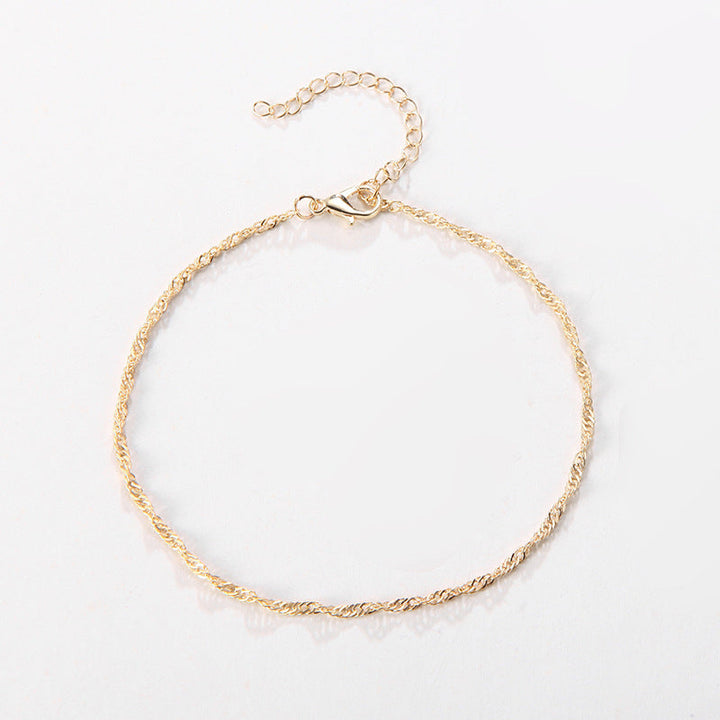 Women's wrist wearing an elegant silver & gold tone twisted chain bracelet. Stylish and adjustable.