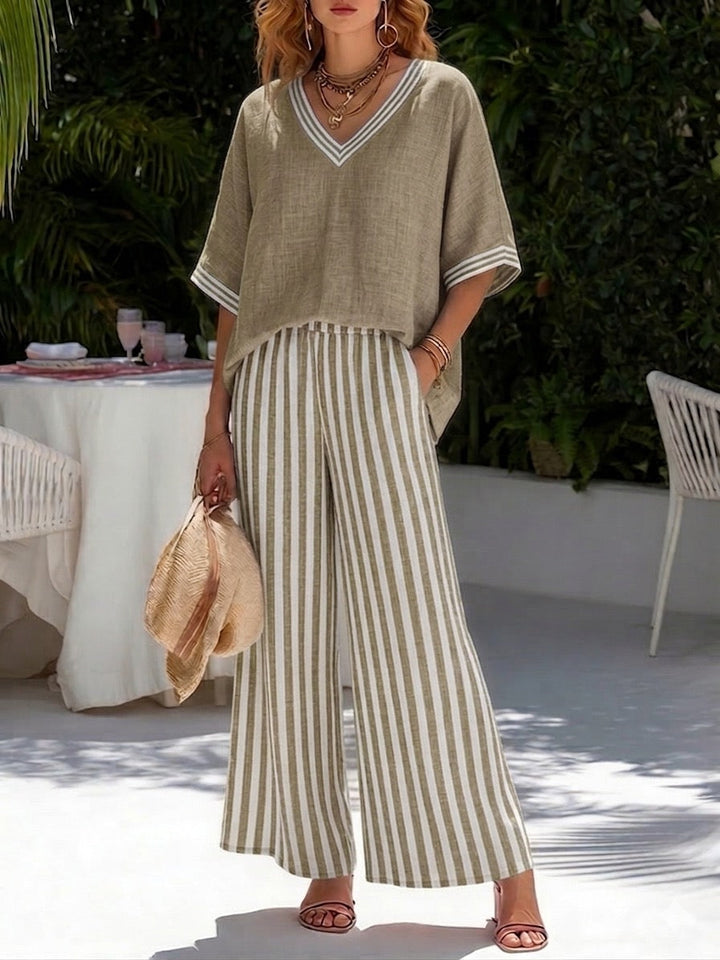 Woman in a stylish V-neck top & flowy striped pants matching set. Casual chic for summer comfort and style.