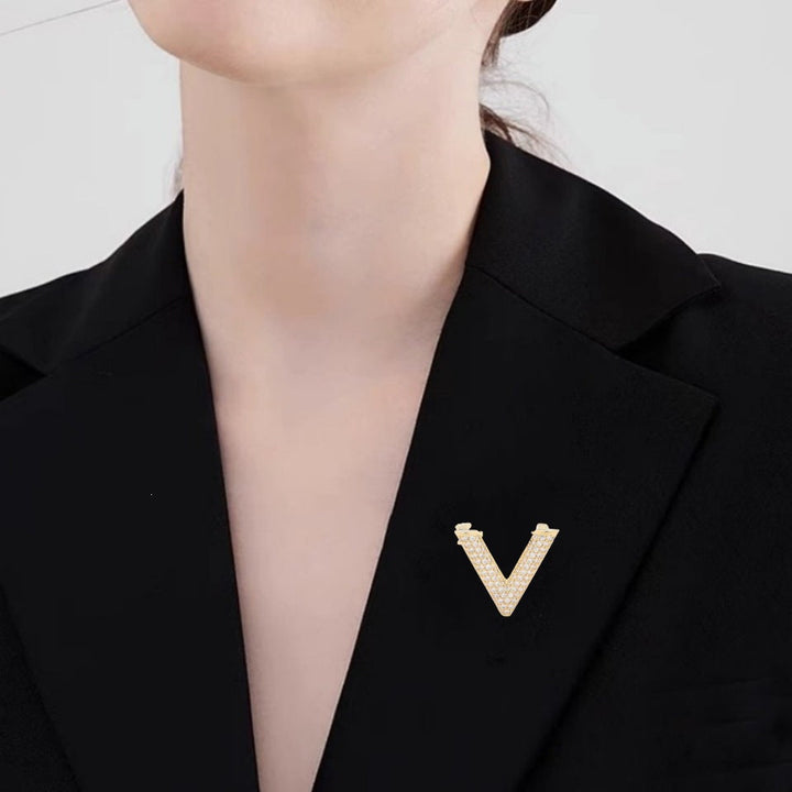 Gold-tone V-shape brooch with dazzling crystals, a chic women's fashion pin.