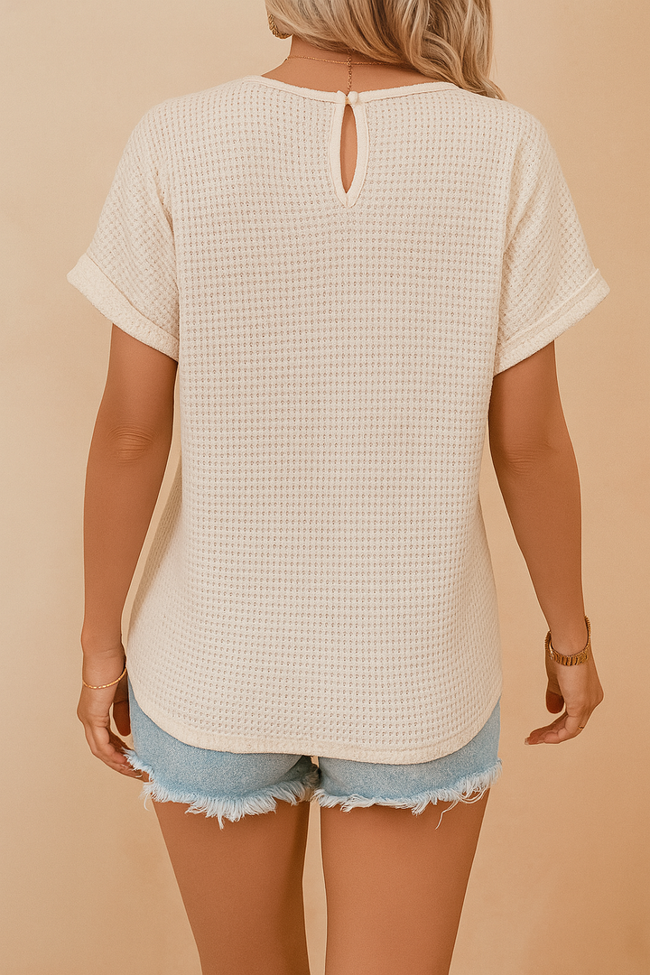 Elegant short-sleeve white openwork top for women, detailed with a decorative neckline. Ideal for chic casual summer wear.
