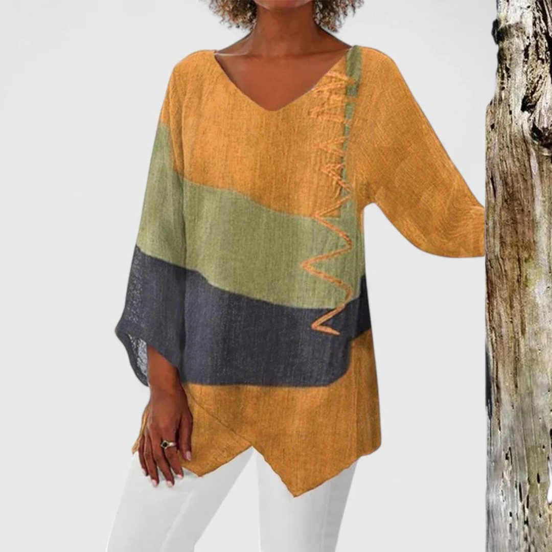 Sophisticated women's V-neck tunic, plus size friendly, featuring a vibrant artistic print and asymmetrical hem.