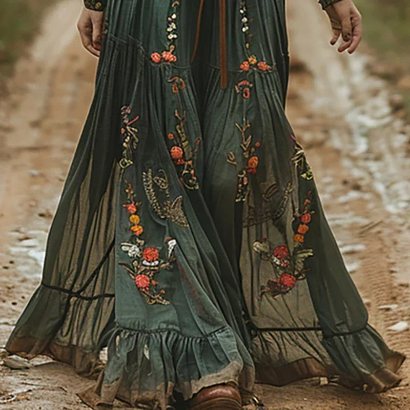 Elegant women's bohemian maxi dress featuring intricate embroidery, flowy skirt, and stylish sheer sleeves.