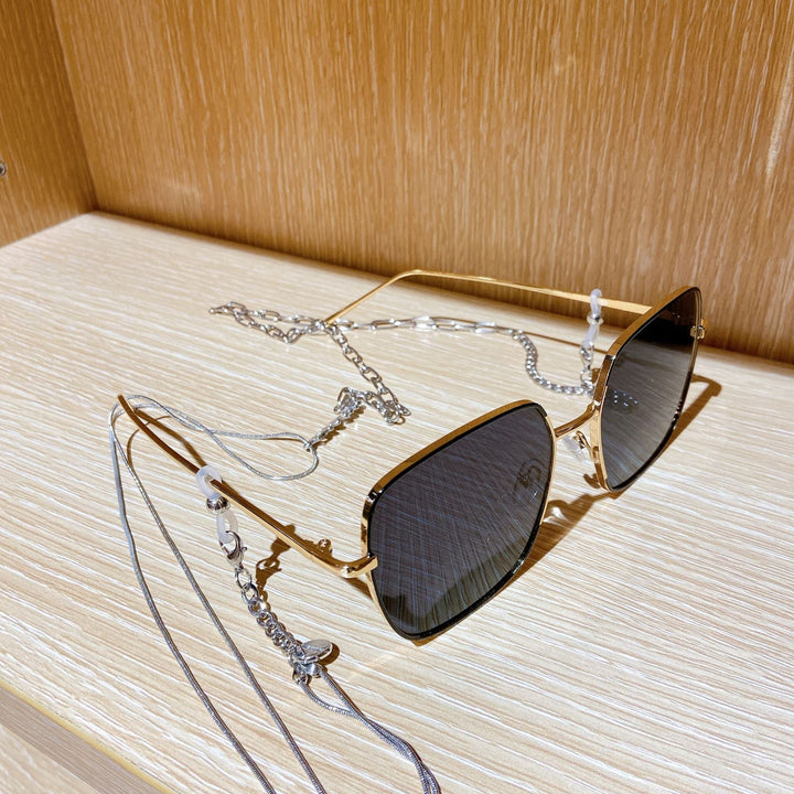 Stylish square frame sunglasses for women, complete with a fashionable chain strap. Ideal for UV protection.