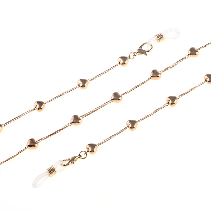 Close-up of a women's fashion glasses chain with sparkling heart pendants. Ideal stylish eyewear accessory.