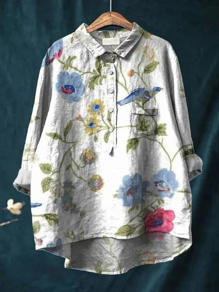Flat lay of a vibrant floral long sleeve button-up blouse for women. Relaxed fit, ideal spring fashion.