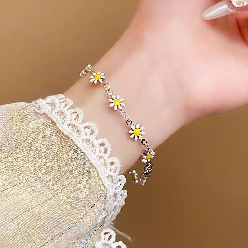 Dainty women's floral charm bracelet with colorful daisy pendants, an elegant fashion jewelry accessory.